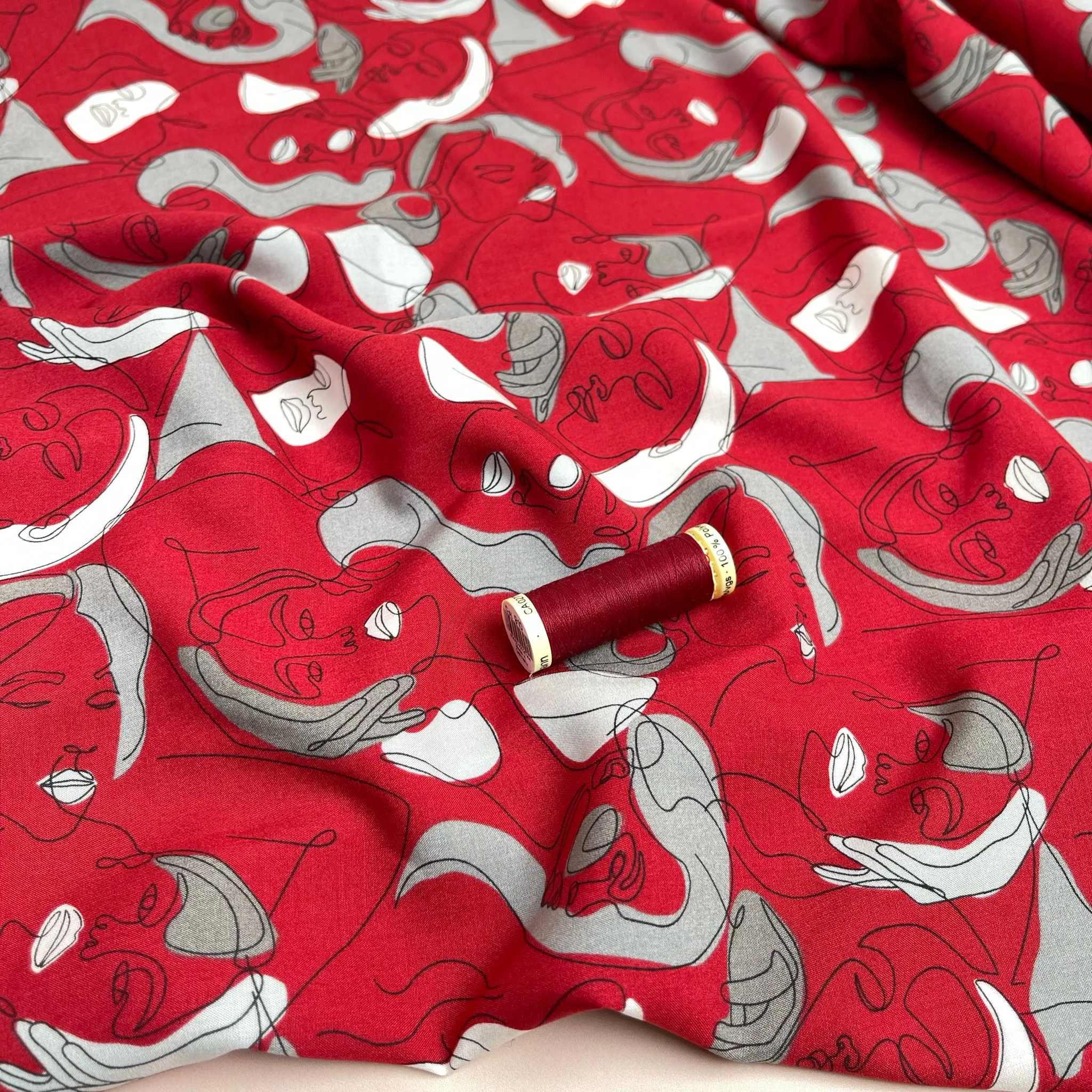 Faces on Red Viscose Fabric
